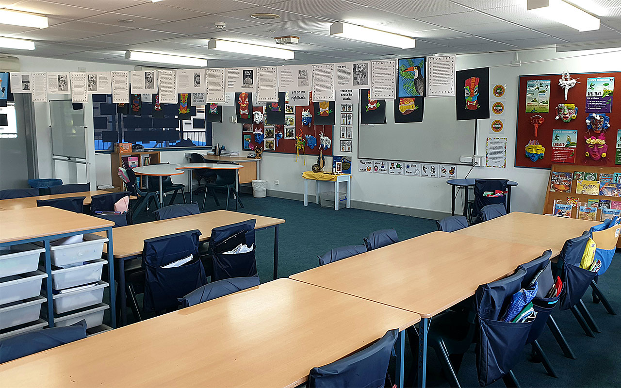 Classroom with student desks, chairs and educational displays on the walls