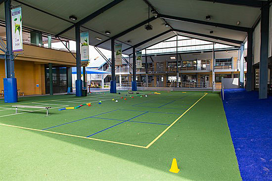 Covered multi‑purpose sports court with cones and equipment set out